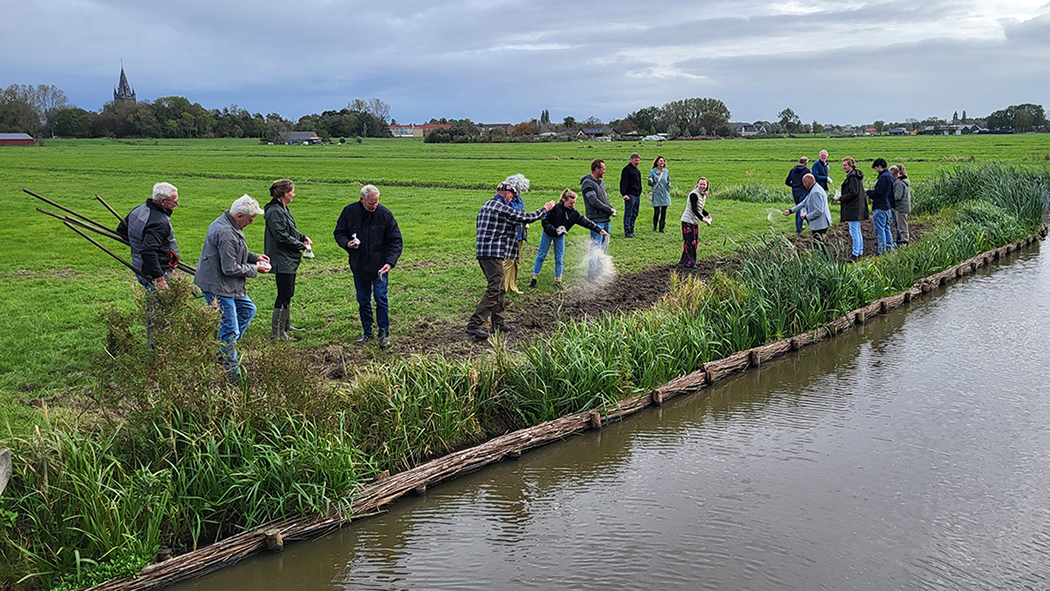 Mensen zaaien bloemen langs de oevers van de Bovenkerkerpolder.jpg